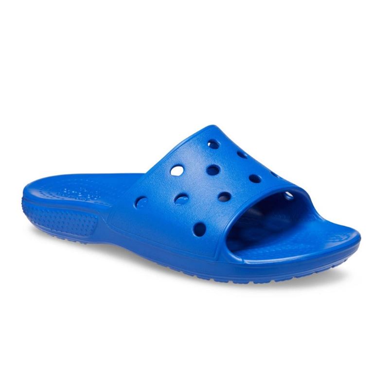 Lahki in udobni Crocs Classic Slide Kids – otroški natikači v praktičnem slide dizajnu za hitro obuvanje in brezskrbne poletne dni. Croslite™ material zagotavlja mehko blaženje, lahkotnost in udobje pri vsakem koraku, zato so idealni za plažo, bazen ali vsakodnevno igro