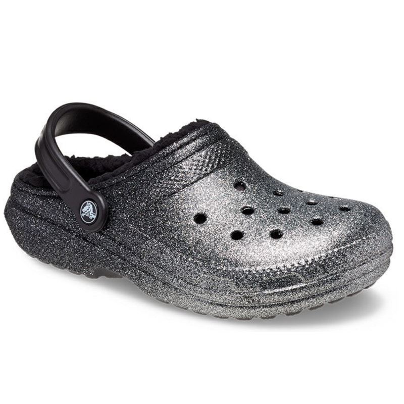 Bleščeči in udobni Crocs Classic Glitter Lined Clog – topli natikači z mehko notranjo podlogo in sijočim glitter dizajnom, ki združujejo udobje, toplino in moderen, igriv videz. Idealni za hladnejše dni doma ali na prostem, kjer želiš dodatno udobje in malo sijaja.