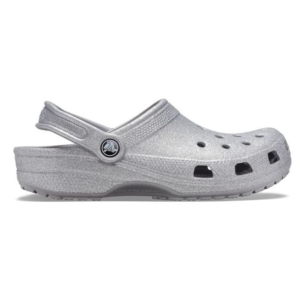 Crocs Classic Glitter Clog 205942 so udobni in lahki natikači z bleščečim glitter dizajnom, ki združujejo prepoznavno Crocs udobje in moderen, izrazit videz. Izdelani iz Croslite™ materiala zagotavljajo mehko blaženje, vodoodpornost in enostavno čiščenje, zato so primerni za vsakodnevno nošenje in modne kombinacije.