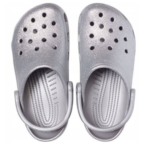 Crocs Classic Glitter Clog 205942 so udobni in lahki natikači z bleščečim glitter dizajnom, ki združujejo prepoznavno Crocs udobje in moderen, izrazit videz. Izdelani iz Croslite™ materiala zagotavljajo mehko blaženje, vodoodpornost in enostavno čiščenje, zato so primerni za vsakodnevno nošenje in modne kombinacije.