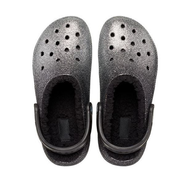 Bleščeči in udobni Crocs Classic Glitter Lined Clog – topli natikači z mehko notranjo podlogo in sijočim glitter dizajnom, ki združujejo udobje, toplino in moderen, igriv videz. Idealni za hladnejše dni doma ali na prostem, kjer želiš dodatno udobje in malo sijaja.
