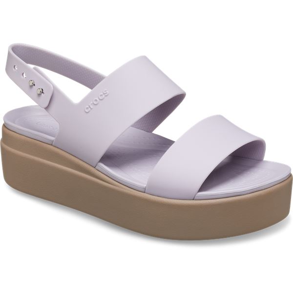 Ženski sandali Crocs Brooklyn Low Wedge W 206453 z elegantno nizko polno peto, lahkotno zasnovo in udobnimi paščki za moderen poletni videz.