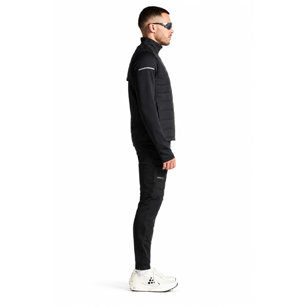 Originalna moška tekaška jakna CRAFT SubZ Jacket 4 M Black v črni barvi. Funkcionalna zimska jakna s trisl ojno protivetrno zaščito in lahko izolacijo spredaj, dvoslojno konstrukcijo z mrežasto podlogo na rokavih in hrbtu, perforiranimi prezračevalnimi območji, dvema žepoma s skritima zadrgama ter odsevnimi elementi. Primerna za zimski tek, intenzivne treninge in rekreacijo v hladnejšem vremenu.