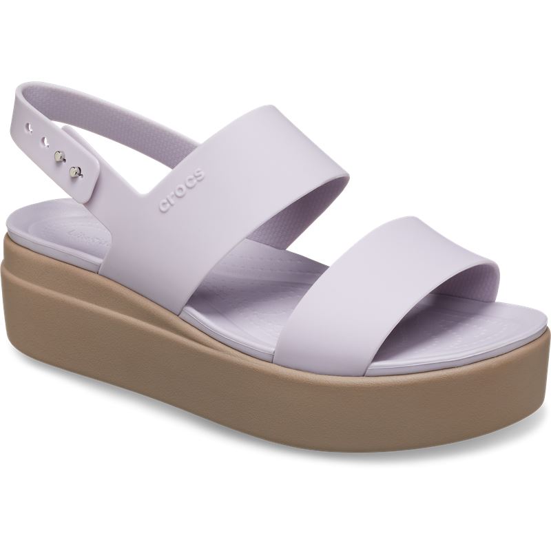 Ženski sandali Crocs Brooklyn Low Wedge W 206453 z elegantno nizko polno peto, lahkotno zasnovo in udobnimi paščki za moderen poletni videz.